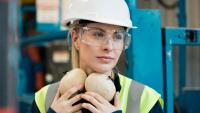 Woman wearing hardhat, safety glasses, and ear protection